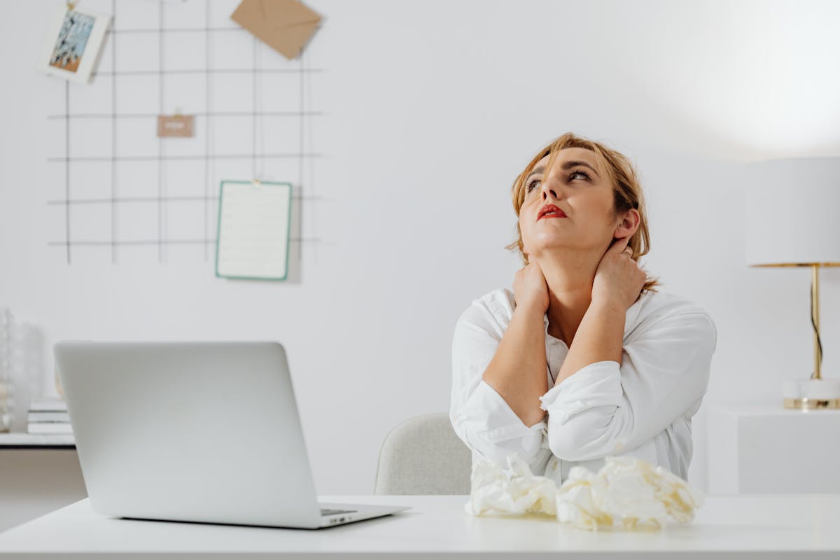 デスクワークで肩が上がった姿勢の30代女性