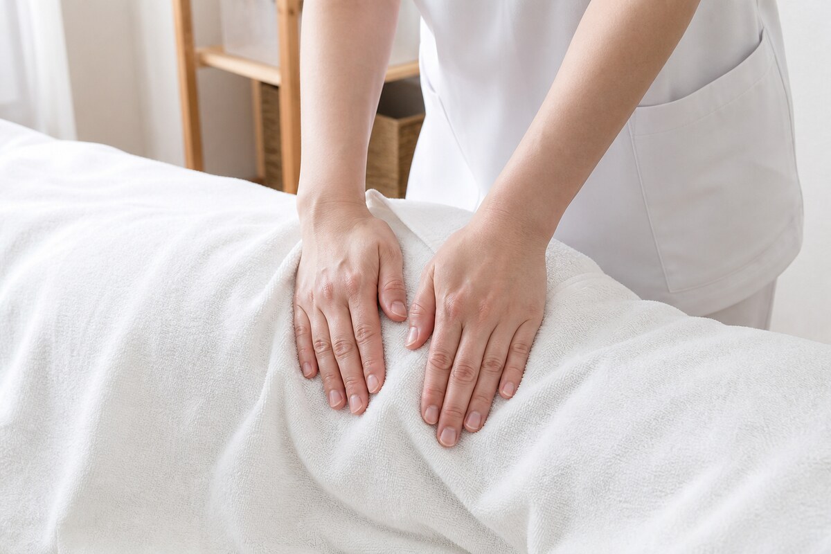 仰向けで股関節の前側に施術を受ける女性|立ち上がりで腰が伸びない原因となる股関節前面の縮みを戻す施術 - 美容整体ReLUMI天王寺